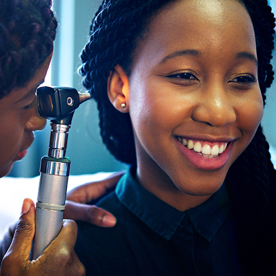 Doctor checking woman's ear